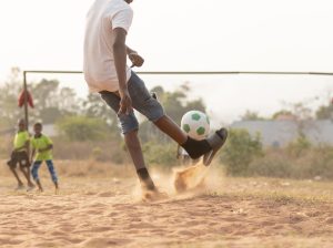 close-up-boy-running-after-ball